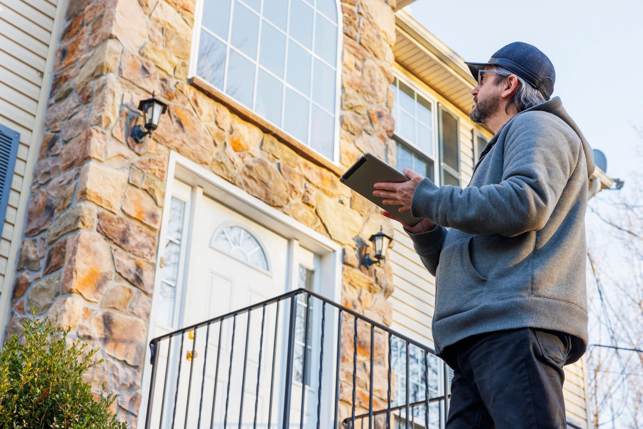 Pest control technician inspecting a home exterior