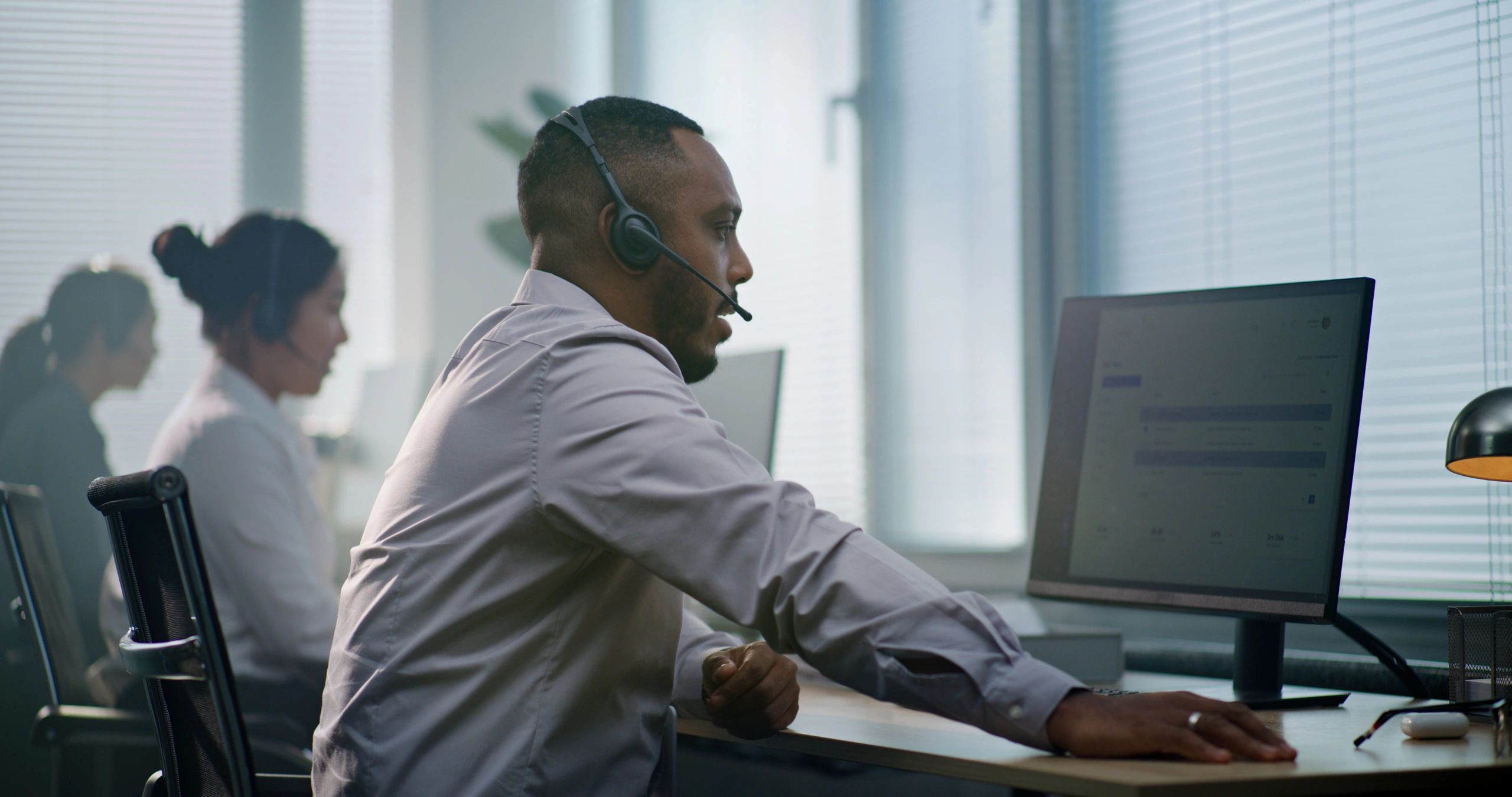 Customer service representative taking a call at a desk