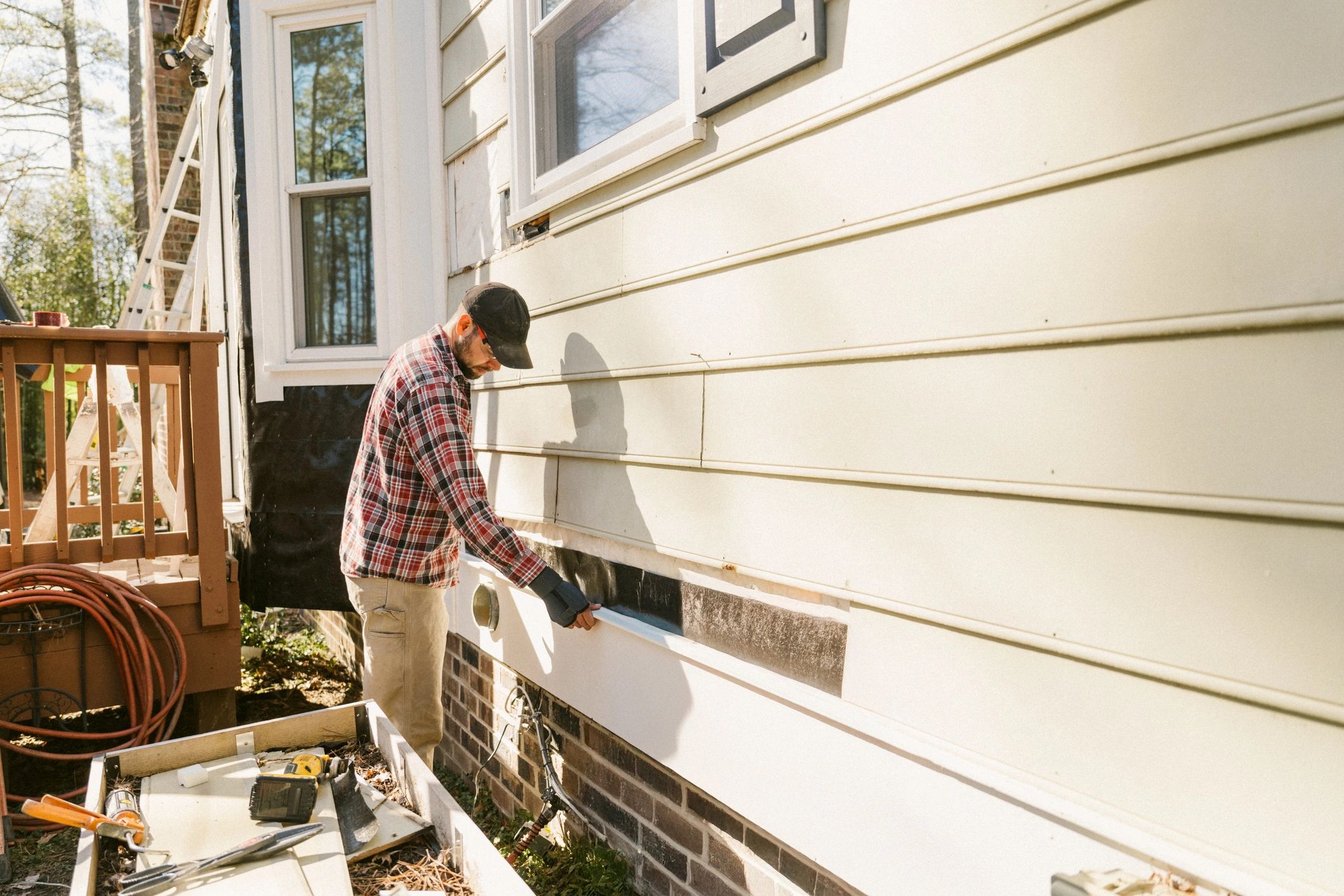 Pest control technician inspecting a home exterior